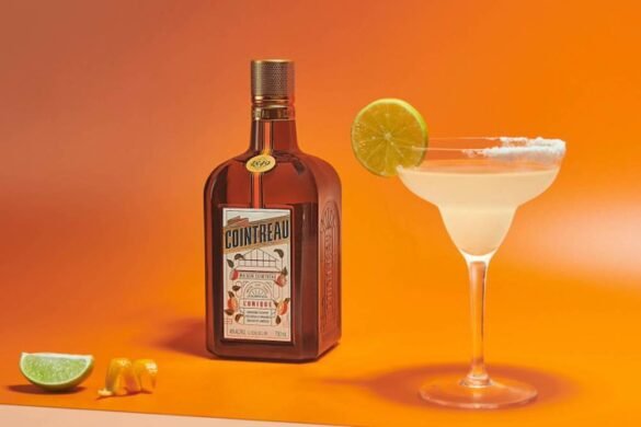 700ml bottle of Cointreau orange liqueur on a bar with fresh orange garnish