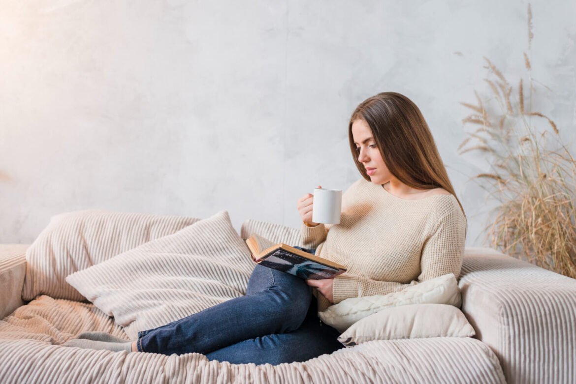 Woman relaxing on the couch with a cup of tea, focusing on mental well-being at home